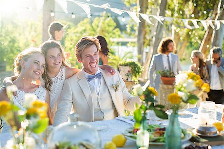 Young couple and bridesmaid during wedding reception in domestic garden Stock Photo - Premium Royalty-Free, Code: 6113-07992182