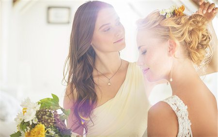 Bridesmaid helping bride with hairstyle in bedroom Stock Photo - Premium Royalty-Free, Code: 6113-07992133