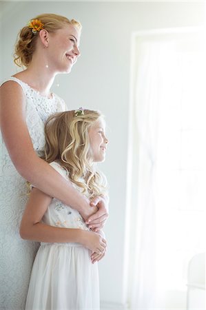 Bride embracing bridesmaid and looking out of window Foto de stock - Sin royalties Premium, Código: 6113-07992137