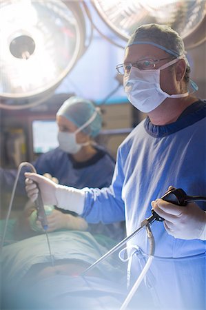 surgical gown - Surgeon performing laparoscopic surgery in operating theater Photographie de stock - Premium Libres de Droits, Code: 6113-07905953