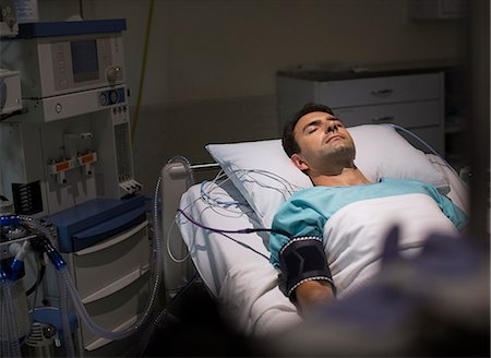 electrical cord - Male patient lying in hospital bed in intensive care unit Stock Photo - Premium Royalty-Free, Code: 6113-07905908