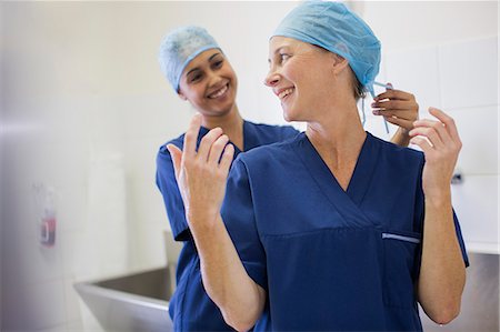 surgical gown - Two smiling surgeons getting ready for surgery Photographie de stock - Premium Libres de Droits, Code: 6113-07905922