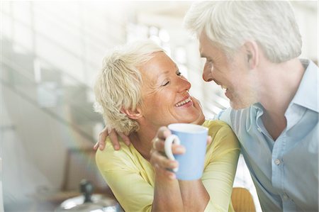 simsearch:6113-07543549,k - Older couple hugging with coffee cup Stock Photo - Premium Royalty-Free, Code: 6113-07906155
