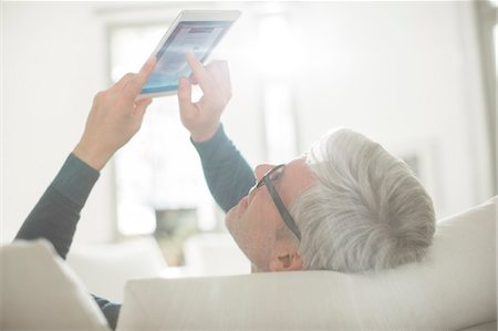 simsearch:6113-07906184,k - Older man using digital tablet in living room Stock Photo - Premium Royalty-Free, Code: 6113-07906176