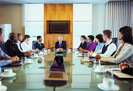 Conference participants looking at man sitting at head of conference table Stock Photo - Premium Royalty-Free, Code: 6113-07906103