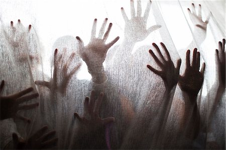 silhouette hand - Silhouette of people raising hands behind transparent curtain Foto de stock - Sin royalties Premium, Código: 6113-07906137