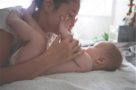 family life - Mother playing with little baby, holding and kissing baby's hands Stock Photo - Premium Royalty-Free, Code: 6113-07906412