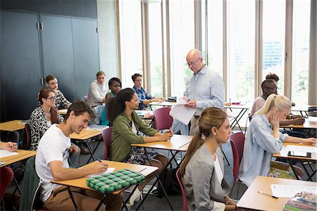 photograph of class room with teachers and students - University students receiving test results from professor Stock Photo - Premium Royalty-Free, Code: 6113-07906501