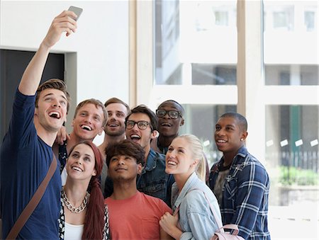 Group of laughing students taking selfie on corridor with large window in background Stock Photo - Premium Royalty-Free, Code: 6113-07906534
