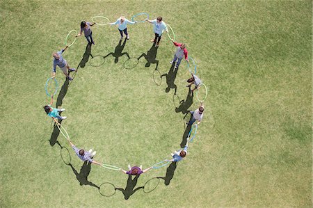 simsearch:6113-07589120,k - Team connected in circle by plastic hoops in sunny field Stock Photo - Premium Royalty-Free, Code: 6113-08087992