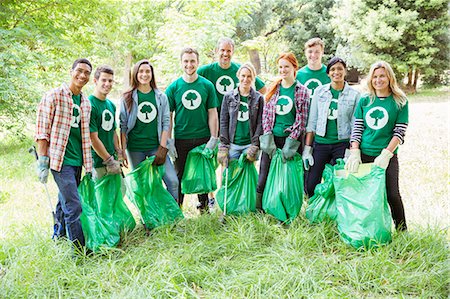 Portrait of smiling environmentalist volunteers picking up trash Stock Photo - Premium Royalty-Free, Code: 6113-08088094