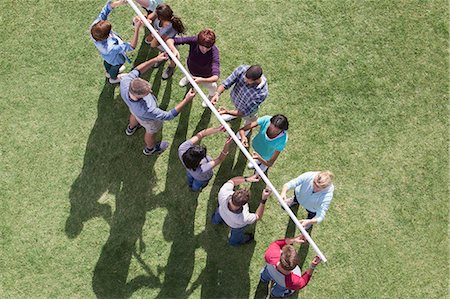 simsearch:6113-07589120,k - Team balancing pole on fingertips in sunny field Stock Photo - Premium Royalty-Free, Code: 6113-08088003