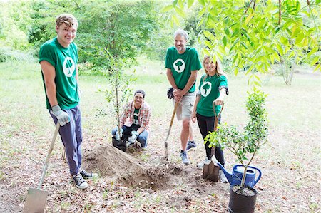 Portrait of confident environmentalist volunteers planting new tree Stock Photo - Premium Royalty-Free, Code: 6113-08088021
