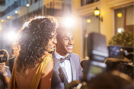 simsearch:6113-08088218,k - Smiling celebrity couple being interviewed and photographed by paparazzi at event Stock Photo - Premium Royalty-Free, Code: 6113-08088195