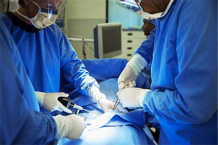 Surgeons performing surgery in operating room Photographie de stock - Premium Libres de Droits, Code: 6113-08088299