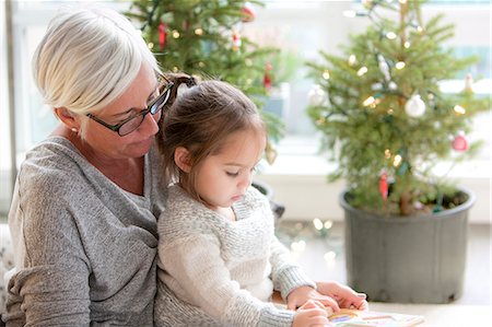 special occasion - Grandmother watching granddaughter drawing in front of Christmas trees Stock Photo - Premium Royalty-Free, Code: 6113-08088543