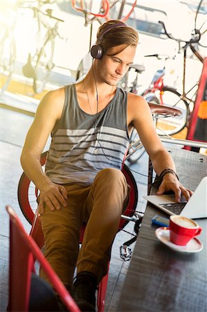 simsearch:625-00801205,k - Man with headphones at laptop in cafe Stock Photo - Premium Royalty-Free, Code: 6113-08171299