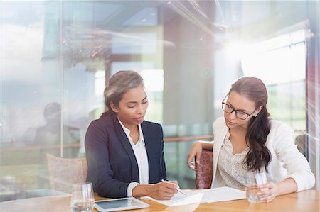 Businesswomen reviewing paperwork in conference room Stock Photo - Premium Royalty-Free, Code: 6113-08171228