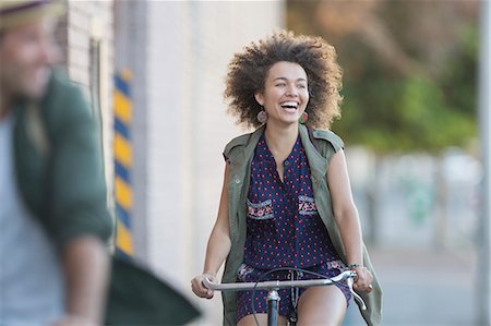 simsearch:6113-08321095,k - Enthusiastic woman with afro riding bicycle Stock Photo - Premium Royalty-Free, Code: 6113-08171359