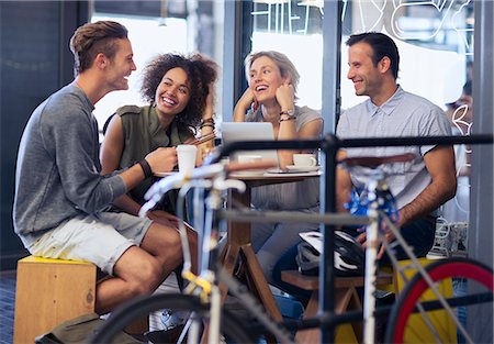 Friends hanging out in cafe behind bicycle Stock Photo - Premium Royalty-Free, Code: 6113-08171376