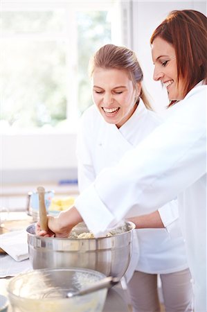 Smiling chefs baking in kitchen Foto de stock - Sin royalties Premium, Código: 6113-08171494
