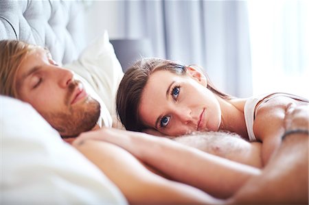 simsearch:6113-06908559,k - Pensive woman laying on sleeping man on bed Foto de stock - Sin royalties Premium, Código: 6113-08171400