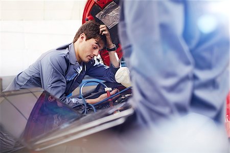 simsearch:6113-08220197,k - Frustrated mechanic looking down at engine in auto repair shop Foto de stock - Sin royalties Premium, Código: 6113-08184347