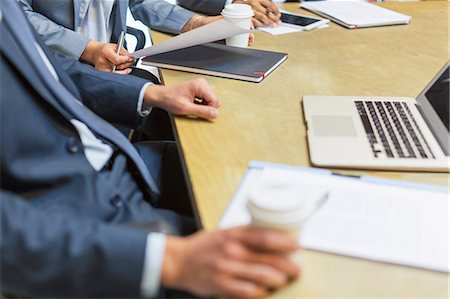 Businessman drinking coffee at laptop in meeting Stock Photo - Premium Royalty-Free, Code: 6113-08184329