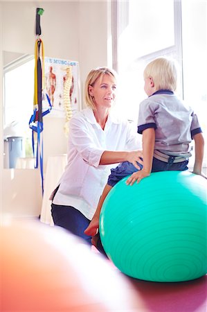 physiotherapist - Physical therapist holding boy on fitness ball Foto de stock - Sin royalties Premium, Código: 6113-08105455