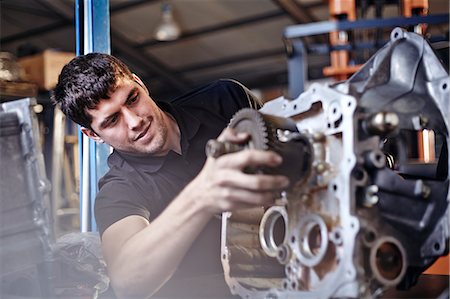 Mechanic fixing part in auto repair shop Stock Photo - Premium Royalty-Free, Code: 6113-08220212