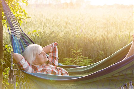 Serene senior woman laying in hammock next to rural wheat field Stock Photo - Premium Royalty-Free, Code: 6113-08220455