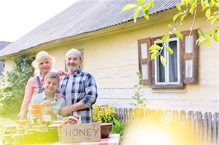 farmers family of three - Portrait proud grandparents and grandson selling honey Stock Photo - Premium Royalty-Free, Code: 6113-08220472