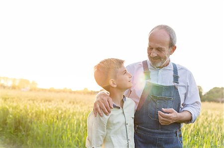 farm and boys - Grandfather farmer and grandson hugging in rural wheat field Stock Photo - Premium Royalty-Free, Code: 6113-08220479