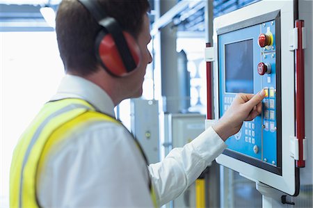 switchboard operator - Worker with ear protectors at control panel in machinery Stock Photo - Premium Royalty-Free, Code: 6113-08393630