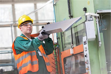 simsearch:6113-08393850,k - Worker in protective workwear examining steel part in factory Photographie de stock - Premium Libres de Droits, Code: 6113-08393863