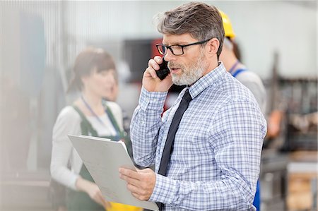 simsearch:649-07520071,k - Businessman with clipboard talking on cell phone in factory Stock Photo - Premium Royalty-Free, Code: 6113-08393892