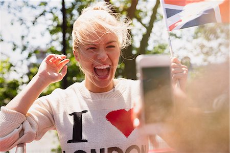 simsearch:6113-07648679,k - Enthusiastic woman waving British flag being photographed Stock Photo - Premium Royalty-Free, Code: 6113-08321113