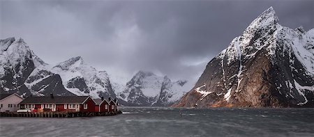 Snow covered mountain range above fishing village, Hamnoya, Lofoten Islands, Norway Stock Photo - Premium Royalty-Free, Code: 6113-08321254