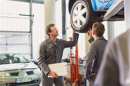 simsearch:6113-08220197,k - Mechanics examining and discussing tire in auto repair shop Foto de stock - Sin royalties Premium, Código: 6113-08321358