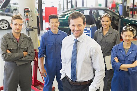 five (quantity) - Portrait confident businessman and mechanics in auto repair shop Stock Photo - Premium Royalty-Free, Code: 6113-08321442