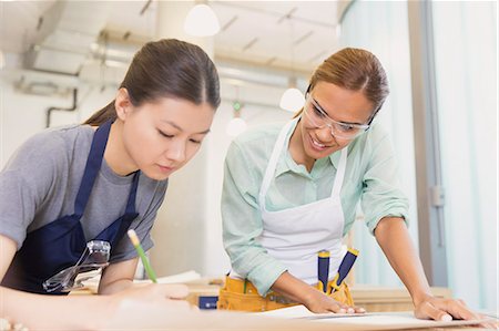 diagrammatic - Female carpenters drafting plans in workshop Stock Photo - Premium Royalty-Free, Code: 6113-08321407