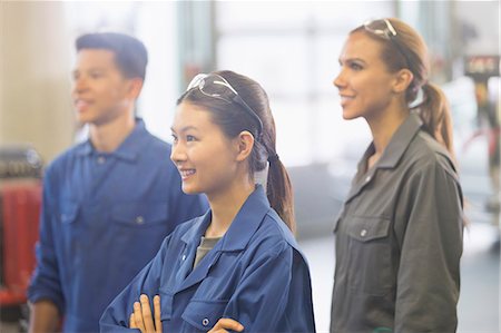 pictures - Smiling mechanics looking away in auto repair shop Stock Photo - Premium Royalty-Free, Code: 6113-08321537