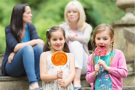 Girls with lollipops in park Stock Photo - Premium Royalty-Free, Code: 6113-08321647