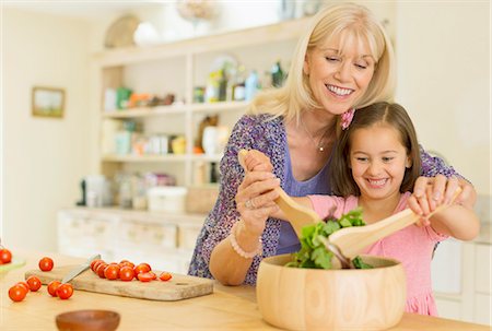 Grandmother and granddaughter tossing salad in kitchen Stock Photo - Premium Royalty-Free, Code: 6113-08321652