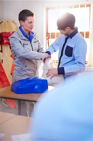 simsearch:400-07411030,k - Instructor guiding student with manual resuscitator in CPR training class Stock Photo - Premium Royalty-Free, Code: 6113-08321680