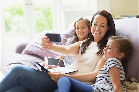 simsearch:649-06304951,k - Mother and daughters taking selfie on living room sofa Stock Photo - Premium Royalty-Free, Code: 6113-08321626