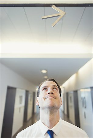 simsearch:700-00357727,k - Businessman looking up at arrow overhead Stock Photo - Premium Royalty-Free, Code: 6113-08549958