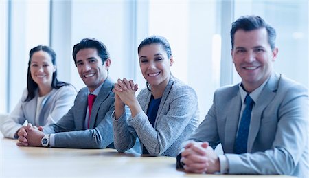 simsearch:6113-07159049,k - Portrait of smiling business people sitting in a row in conference room Stock Photo - Premium Royalty-Free, Code: 6113-08549978