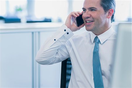 simsearch:649-07520071,k - Smiling businessman talking on cell phone in office Stock Photo - Premium Royalty-Free, Code: 6113-08550000