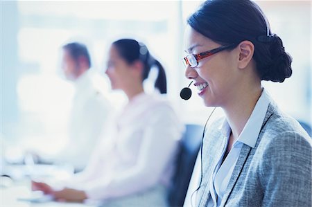 Smiling businesswoman talking on the phone with headset Stock Photo - Premium Royalty-Free, Code: 6113-08550018